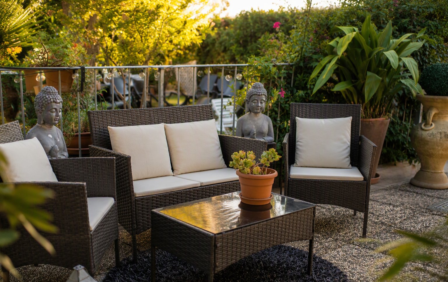 Il salottino del giardino con i divanetti in vimini tra il verde